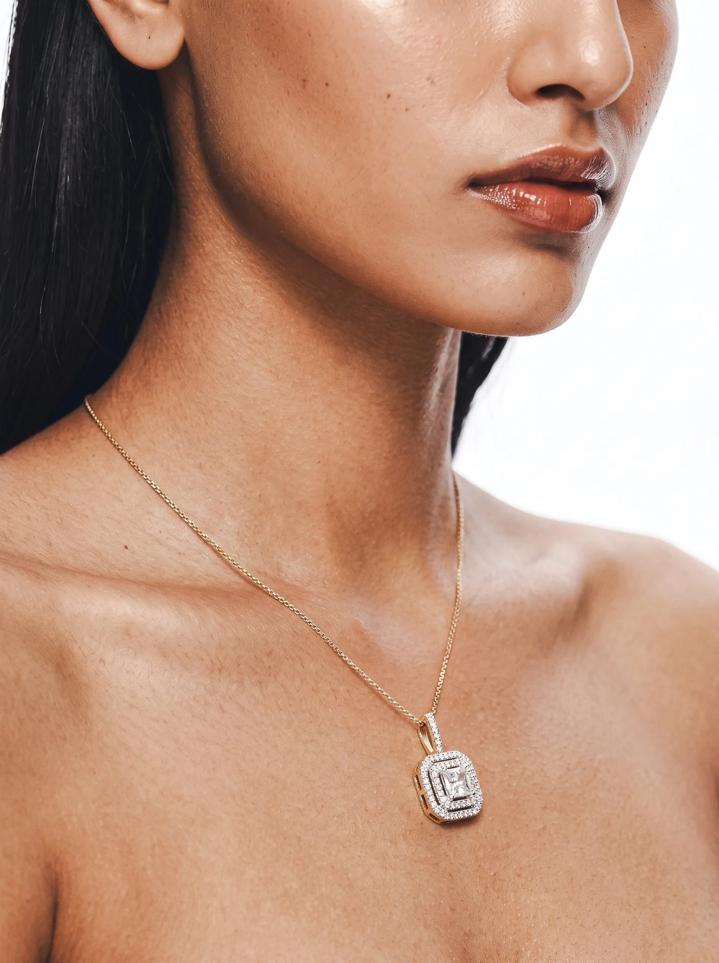 Carré Pendant, No. 008, an emerald cut diamond on a gold chain, worn